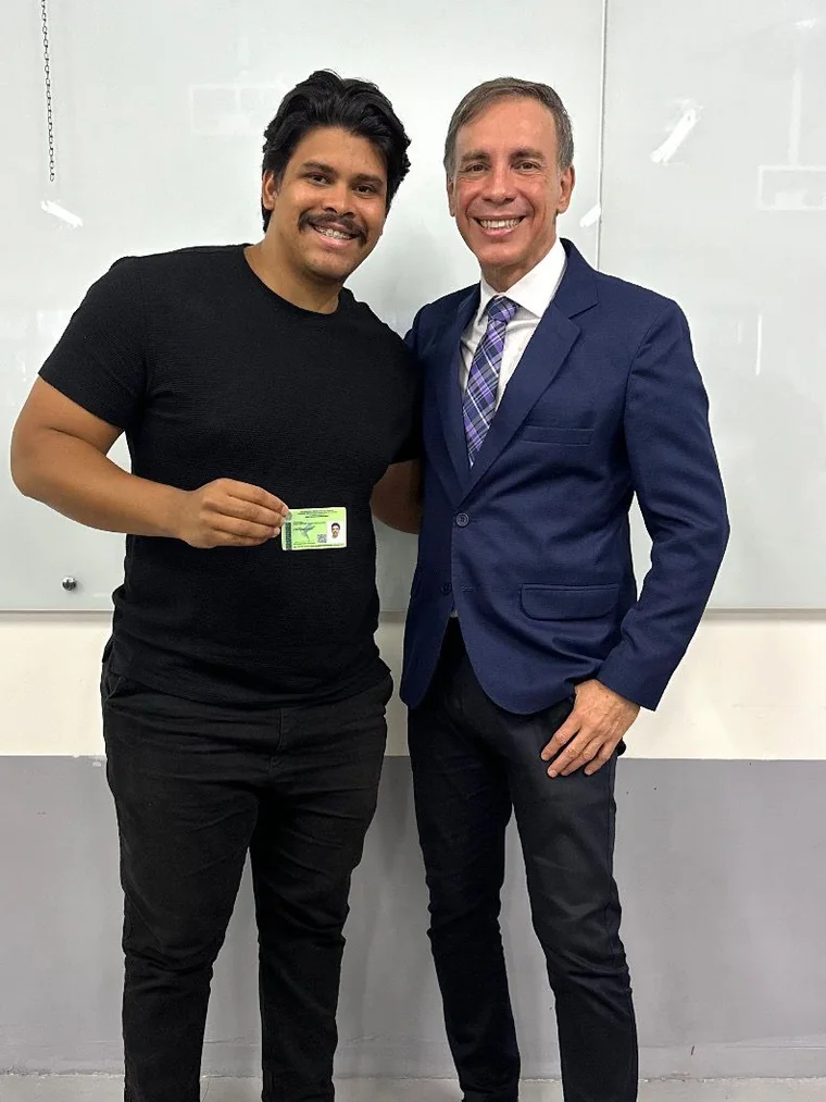 João Wender ao lado do presidente do CRECI-GO segurando a carteira profissional de corretor de imóveis