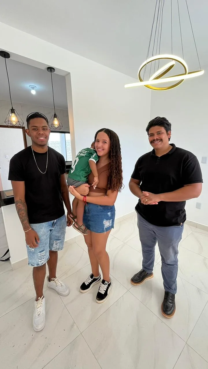 Família com o bebê no colo dentro do apartamento recém entregue, em Planaltina de Goiás