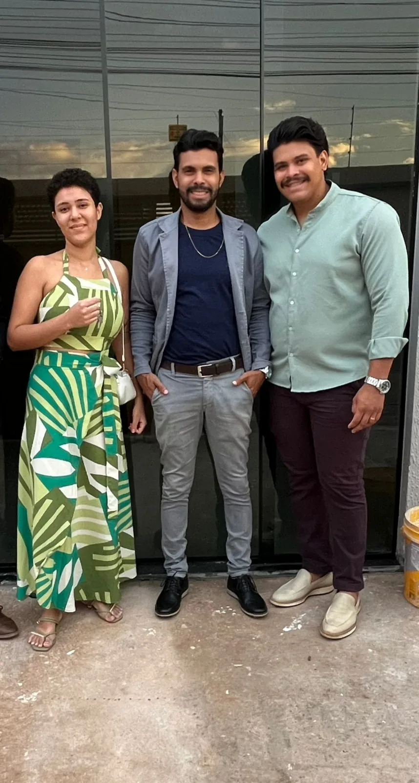 Cliente com a chave na mão em frente ao prédio, ao lado do corretor, em Planaltina de Goiás