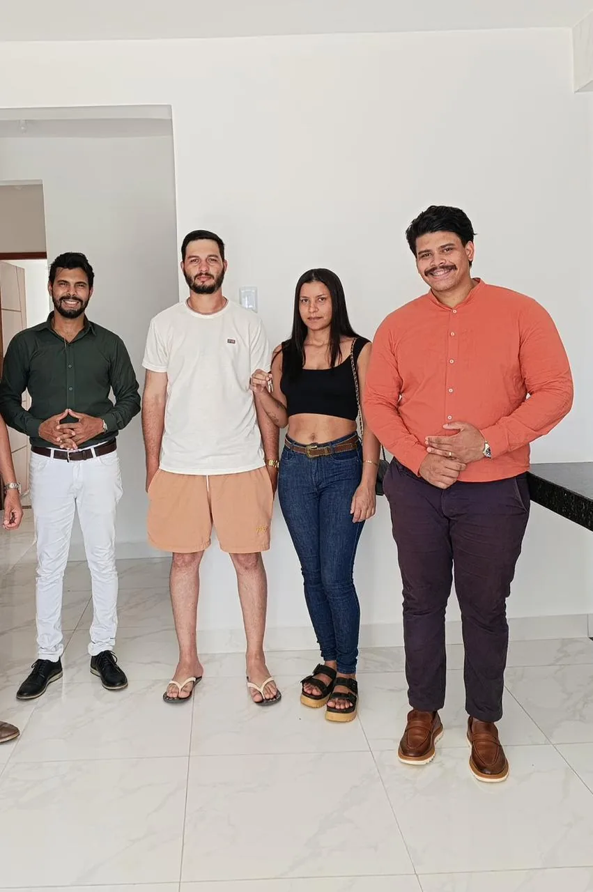 Casal recebendo as chaves dentro da sala do imóvel, em Planaltina de Goiás