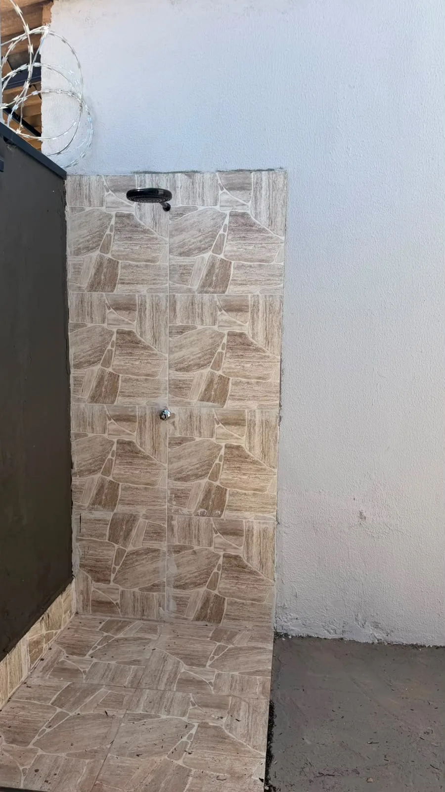 Área externa com parede em pedra rústica