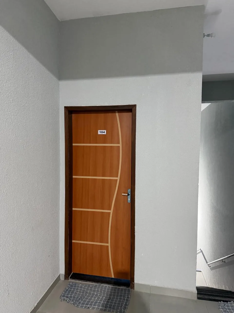Entrada do apartamento com porta de madeira