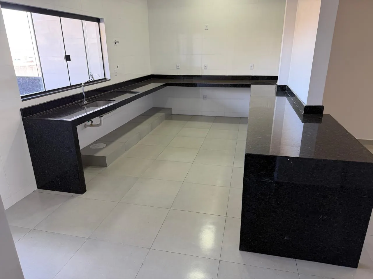 Cozinha em L com bancadas de granito preto