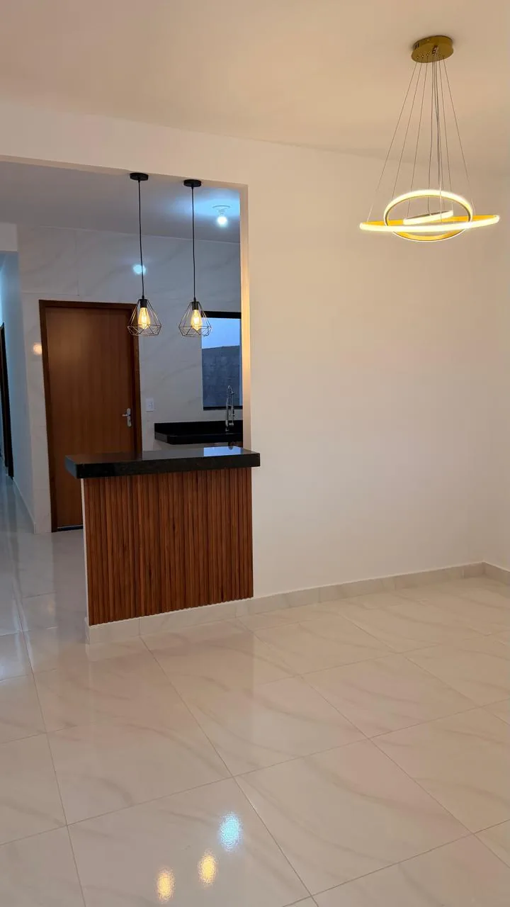 Sala e cozinha integradas com luminária pendente circular