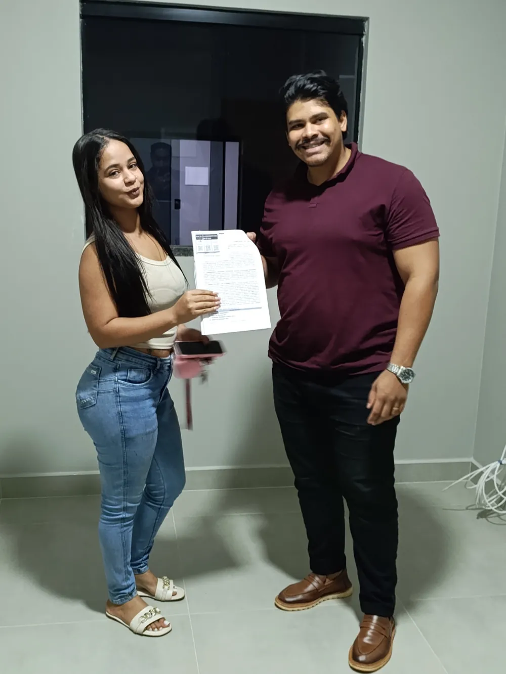 Cliente recebendo a documentação do imóvel das mãos do corretor João Wender